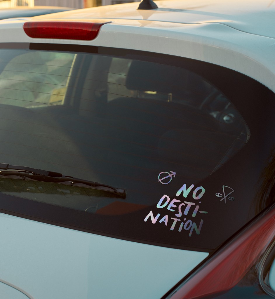 A holographic 'No Destination' decal applied to a car's rear window